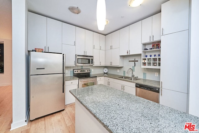 kitchen with stainless steel appliances, light hardwood / wood-style flooring, white cabinetry, and sink