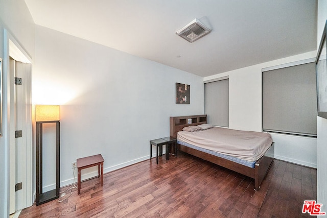 bedroom with dark wood-type flooring