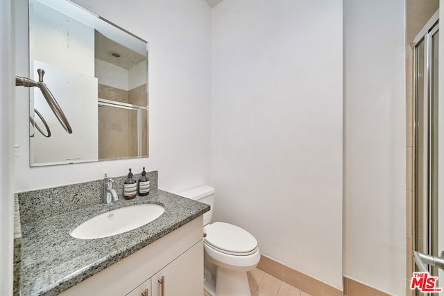 bathroom with toilet, tile patterned flooring, walk in shower, and vanity