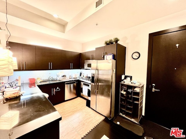 kitchen featuring sink, pendant lighting, appliances with stainless steel finishes, and dark brown cabinets