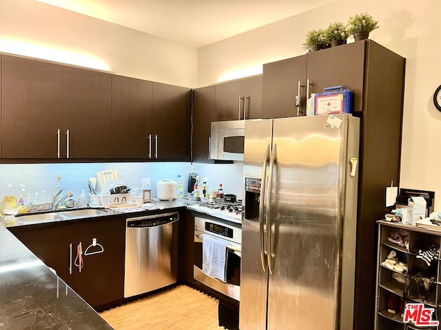 kitchen featuring decorative backsplash, appliances with stainless steel finishes, sink, and dark brown cabinets