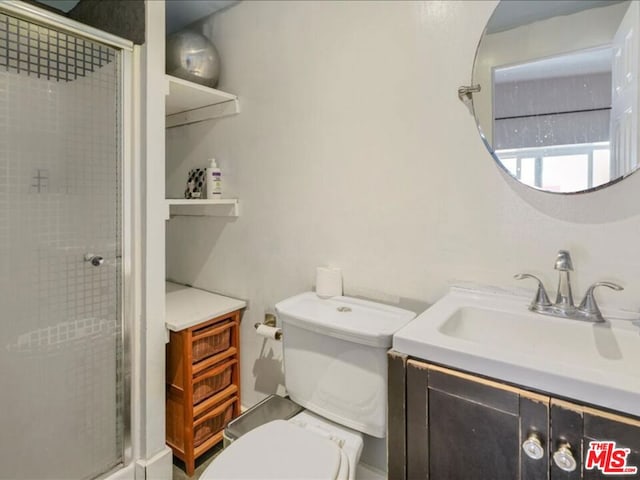 bathroom with vanity, toilet, and a shower with shower door