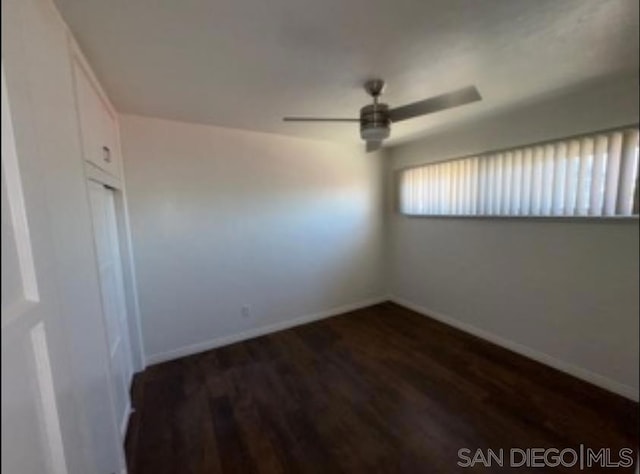 spare room with ceiling fan and dark hardwood / wood-style floors