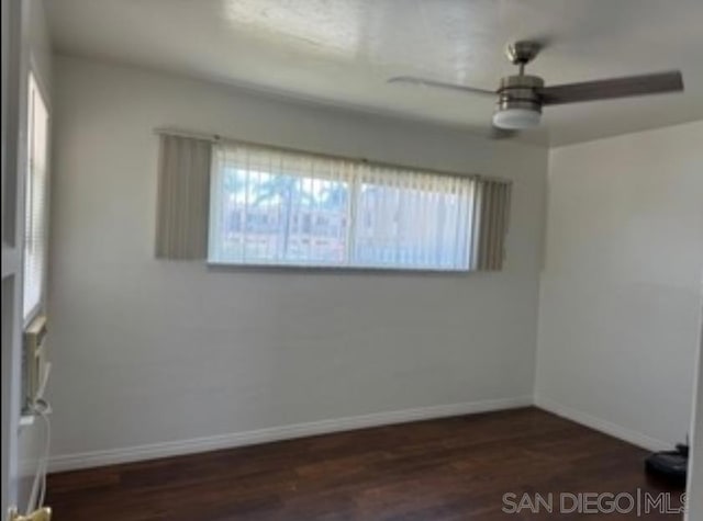 unfurnished room with ceiling fan, a wealth of natural light, and dark hardwood / wood-style floors