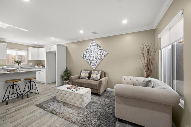 living room featuring ornamental molding and light hardwood / wood-style floors