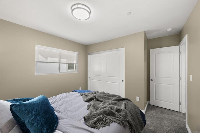 bedroom with a closet and dark colored carpet