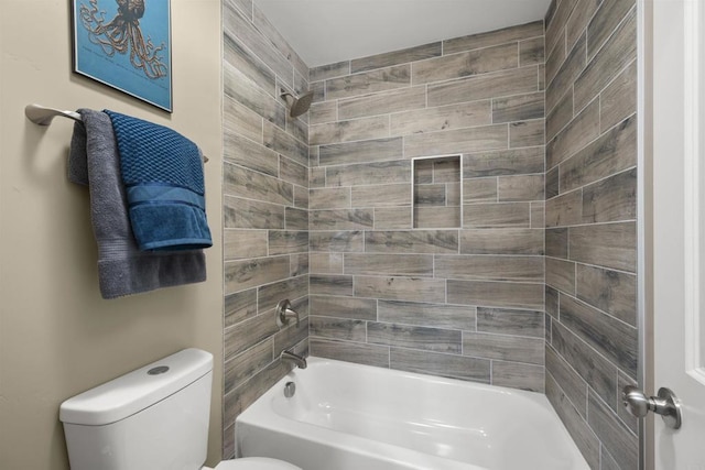 bathroom with tiled shower / bath combo and toilet