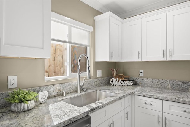 kitchen featuring ornamental molding, white cabinets, and sink