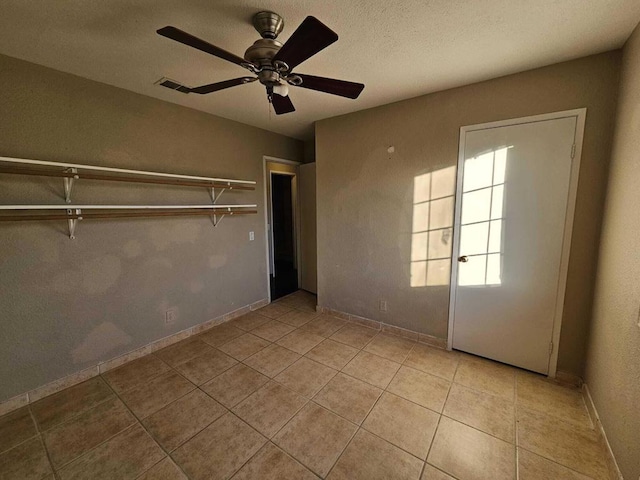 unfurnished bedroom with ceiling fan, a closet, and light tile patterned flooring