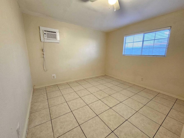 tiled spare room featuring ceiling fan and a wall mounted air conditioner