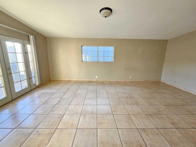 tiled spare room featuring french doors