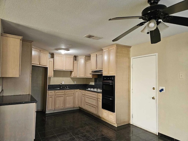 kitchen with a textured ceiling, ceiling fan, light brown cabinetry, and sink