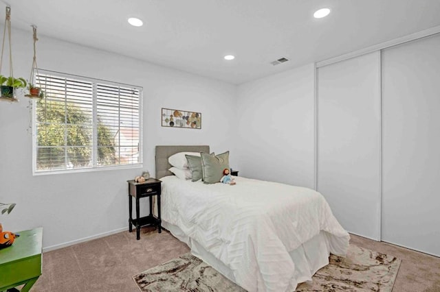 bedroom featuring a closet and light carpet