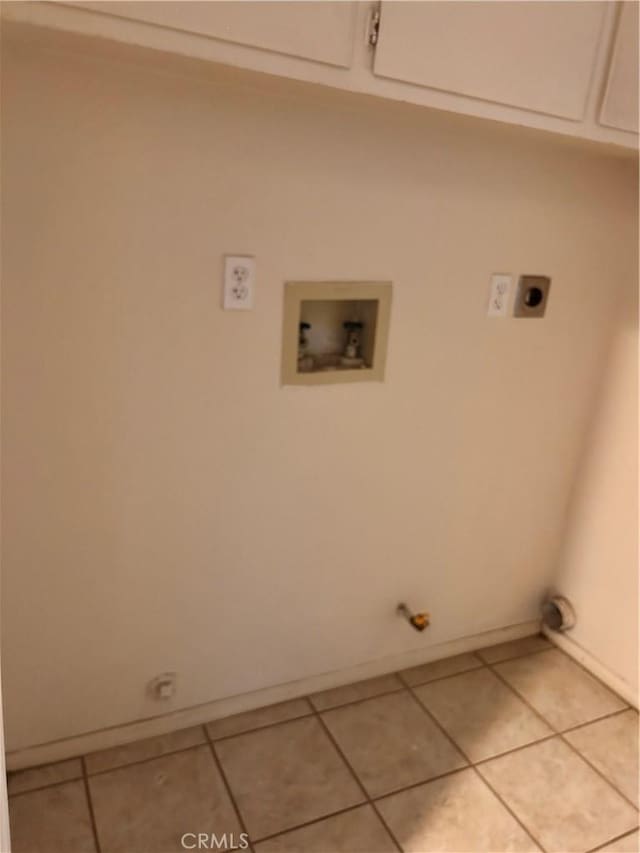 clothes washing area with washer hookup, cabinets, light tile patterned floors, and electric dryer hookup