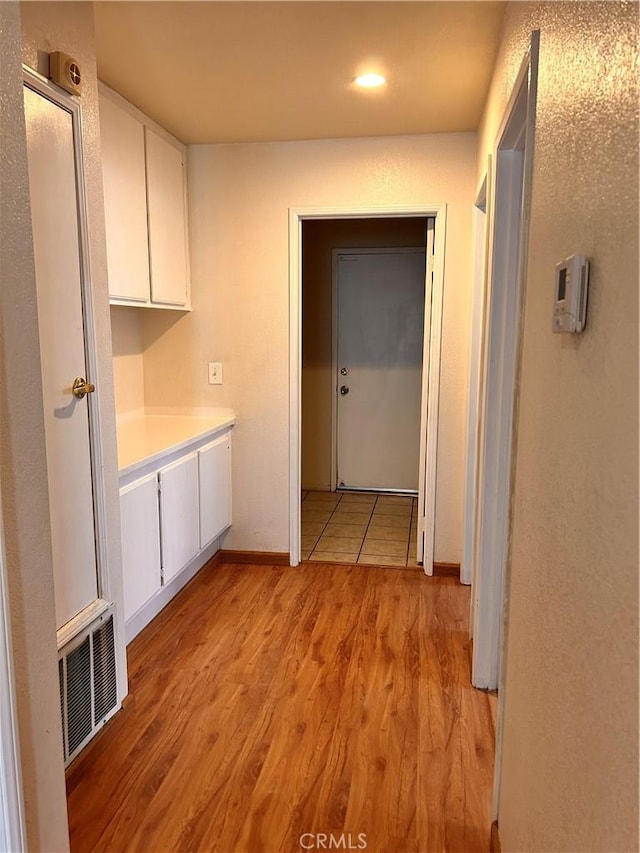 corridor with light hardwood / wood-style floors