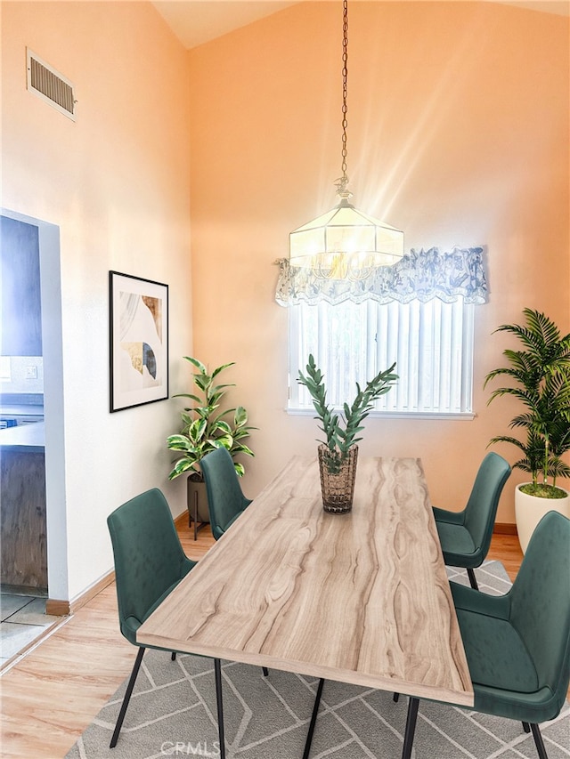 dining room with hardwood / wood-style flooring and a notable chandelier