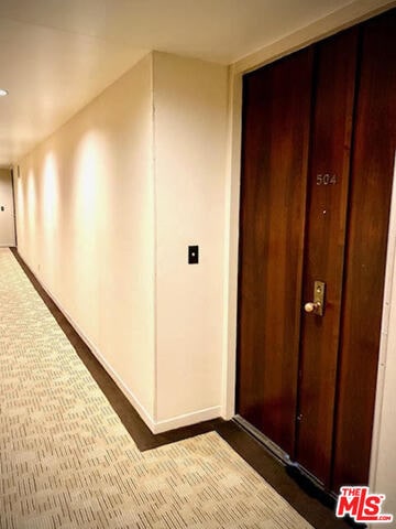 corridor featuring dark carpet