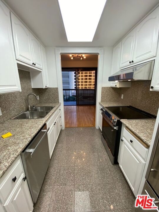 kitchen with electric stove, stainless steel dishwasher, sink, a skylight, and white cabinets