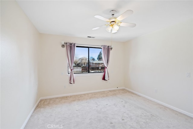 spare room with ceiling fan and light colored carpet