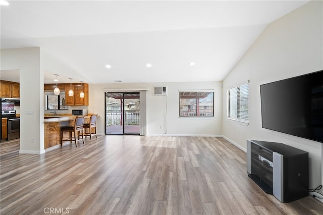 living room featuring light hardwood / wood-style floors, sink, and lofted ceiling