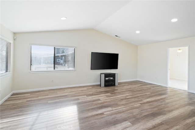 unfurnished living room featuring vaulted ceiling and light hardwood / wood-style floors