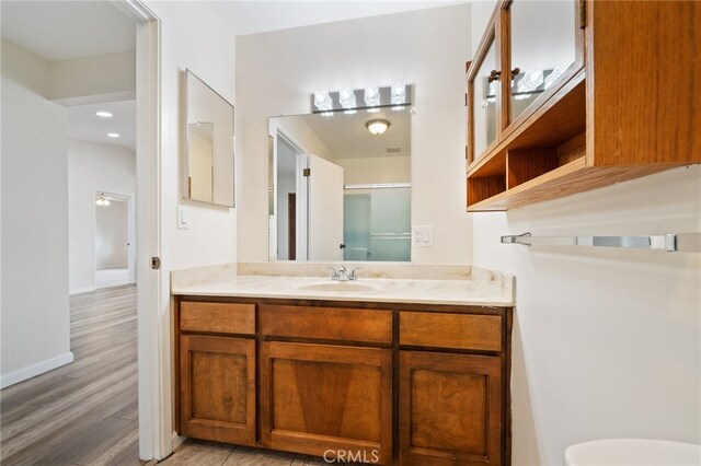 bathroom featuring toilet, vanity, and hardwood / wood-style floors