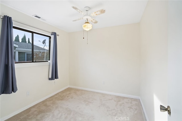 spare room featuring ceiling fan and light carpet