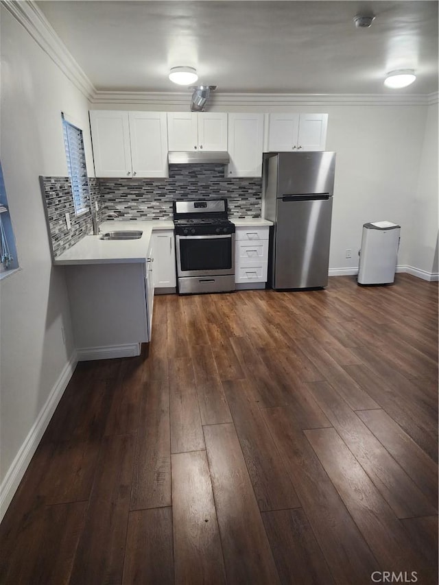 kitchen featuring dark wood finished floors, crown molding, backsplash, appliances with stainless steel finishes, and under cabinet range hood