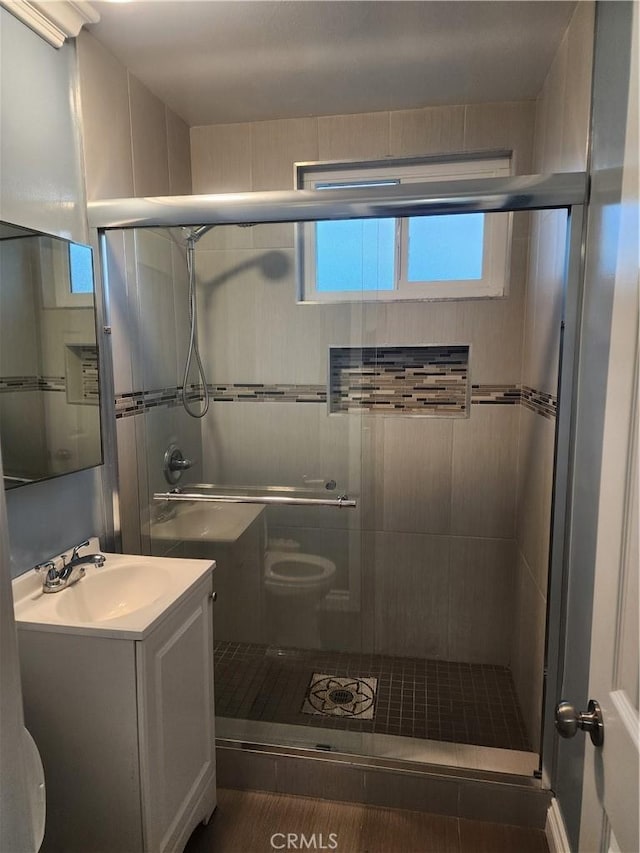 full bathroom featuring toilet, a shower stall, and vanity