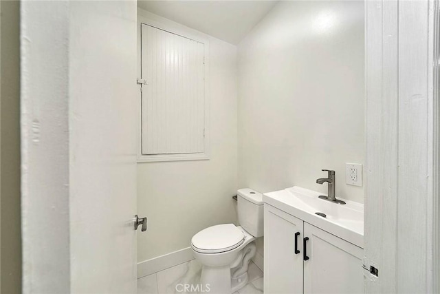 bathroom featuring toilet, baseboards, and vanity