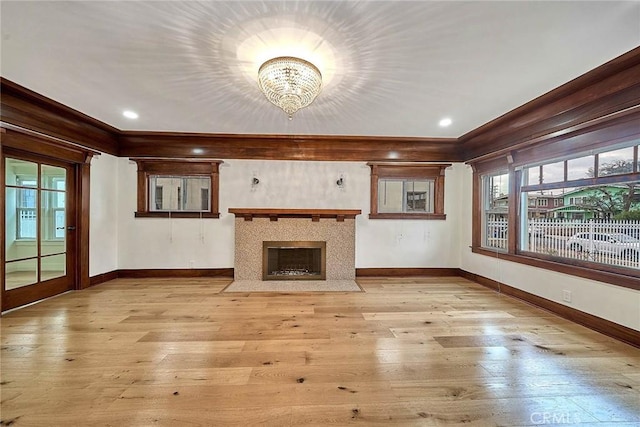 unfurnished living room featuring recessed lighting, light wood-type flooring, a fireplace with flush hearth, and baseboards