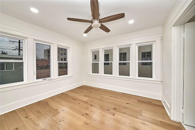 unfurnished sunroom with a ceiling fan