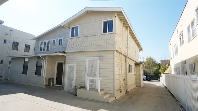 rear view of house featuring fence