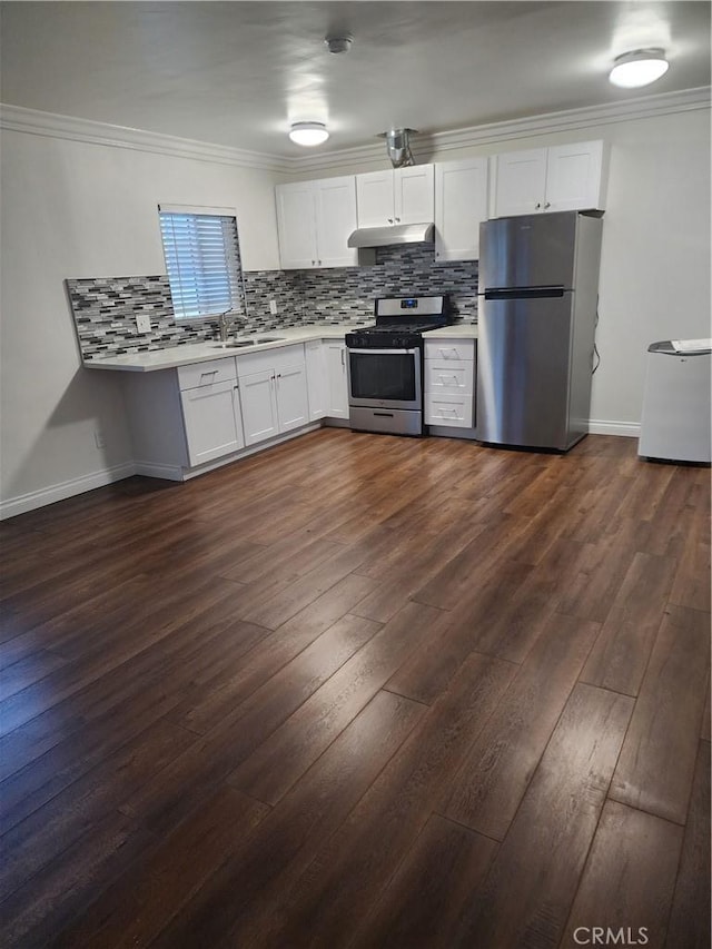 kitchen featuring tasteful backsplash, light countertops, appliances with stainless steel finishes, ornamental molding, and under cabinet range hood