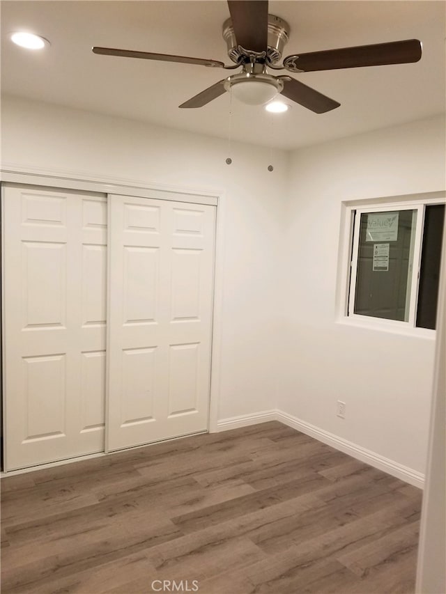 unfurnished bedroom featuring recessed lighting, a closet, a ceiling fan, wood finished floors, and baseboards