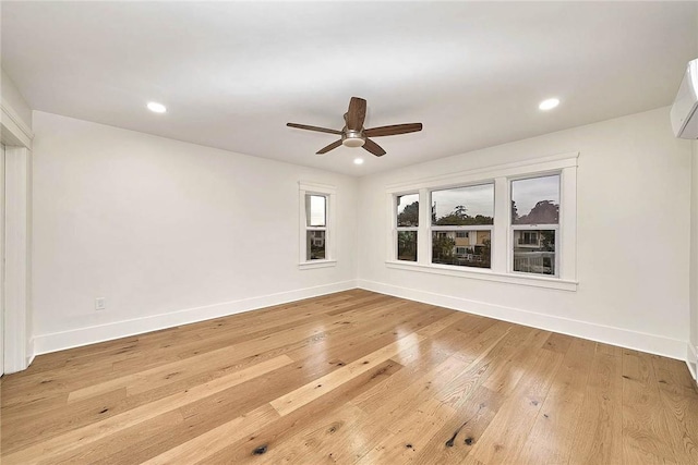 empty room featuring recessed lighting, baseboards, and light wood finished floors