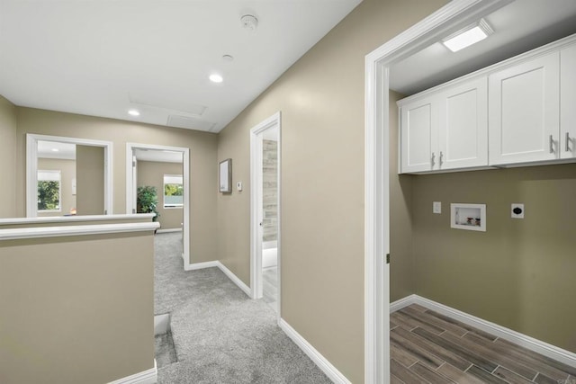 interior space featuring carpet flooring, hookup for a washing machine, electric dryer hookup, and cabinets