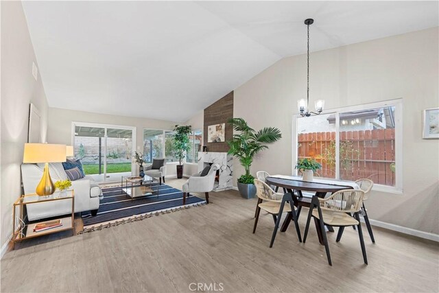 interior space featuring lofted ceiling, wood-type flooring, and an inviting chandelier