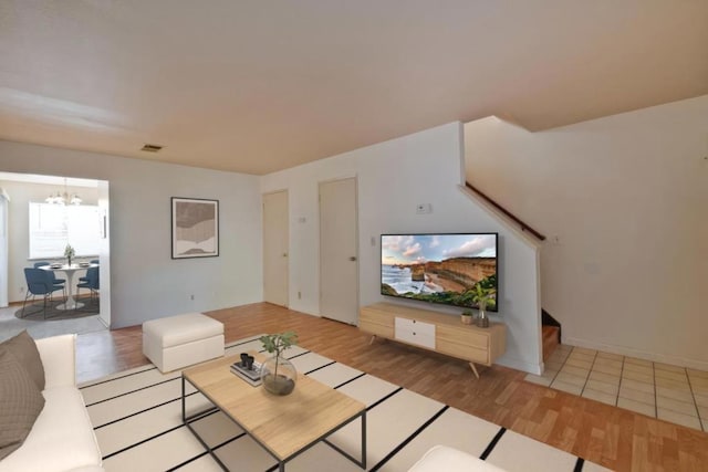 living room with a chandelier and light hardwood / wood-style flooring