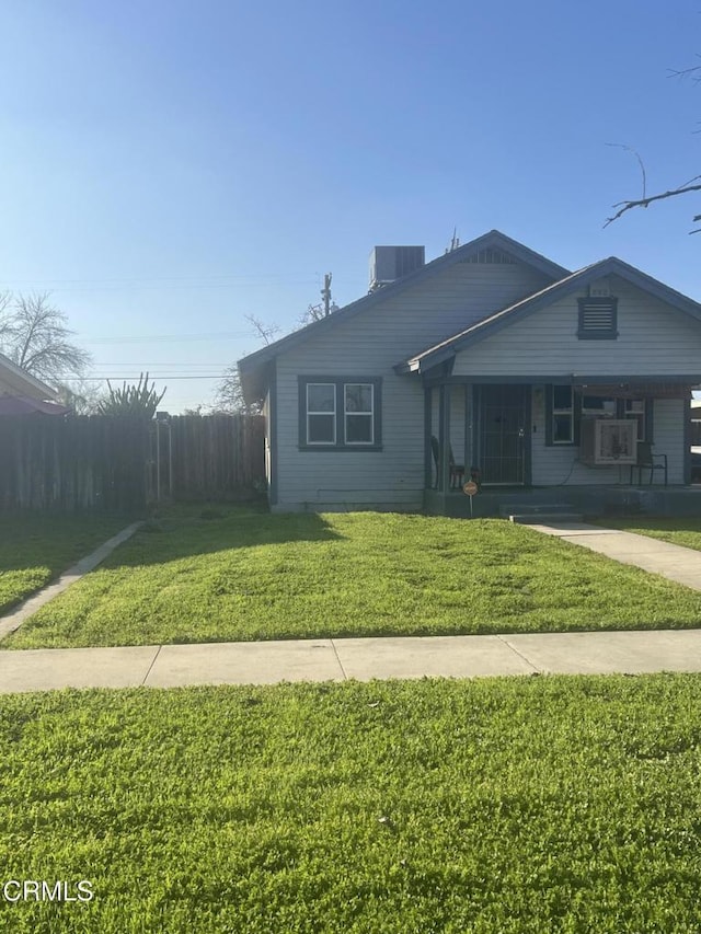 view of front of home featuring a porch, cooling unit, and a front yard