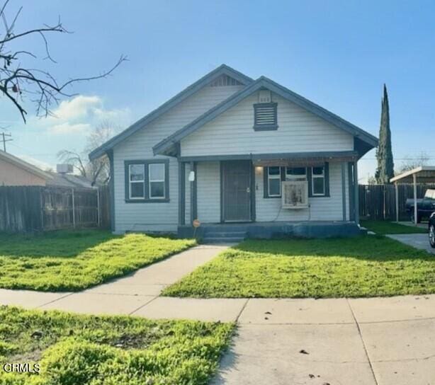 bungalow-style home with a porch, a front lawn, and a carport