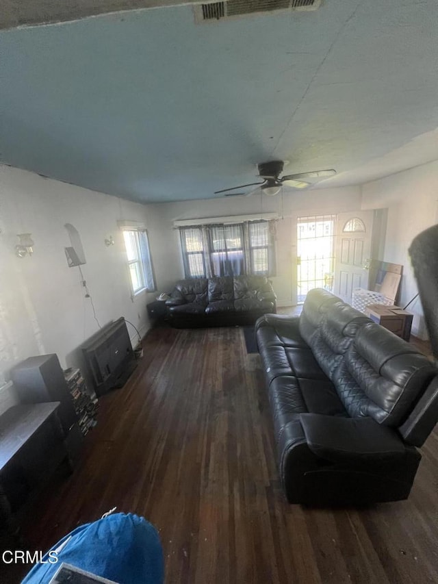 living room featuring ceiling fan, dark wood-type flooring, and plenty of natural light