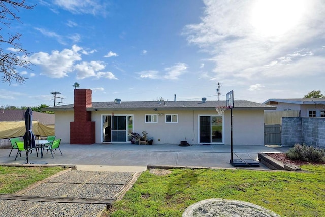 back of property with a patio area and a lawn