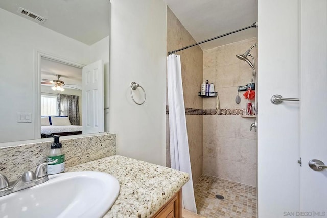 bathroom featuring walk in shower, vanity, and ceiling fan