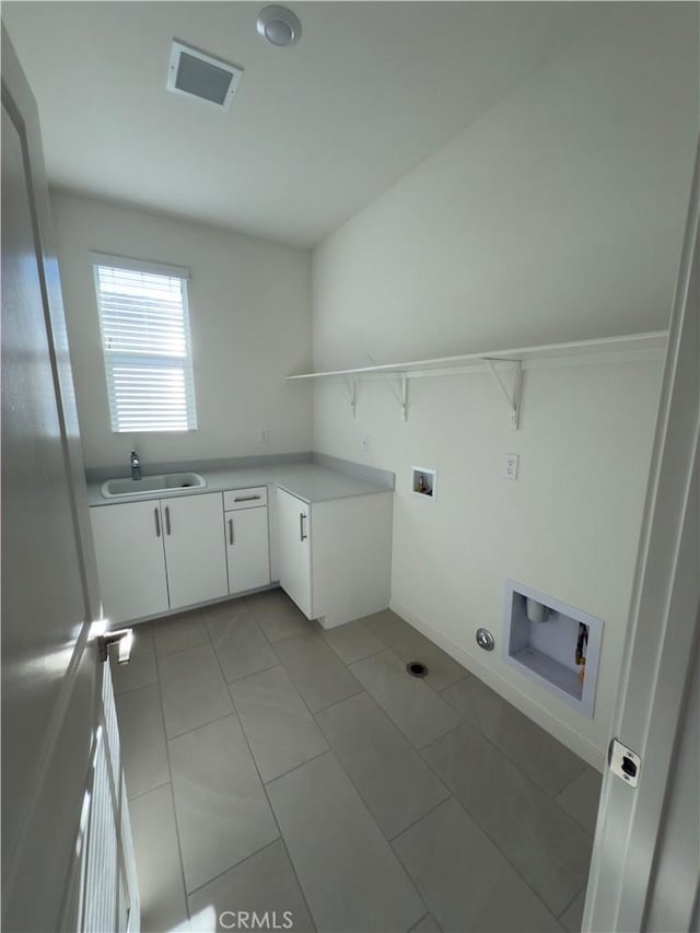 laundry area featuring cabinets, light tile patterned flooring, hookup for a washing machine, and sink