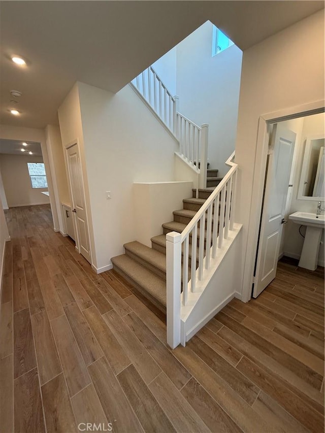 stairway with hardwood / wood-style flooring and sink