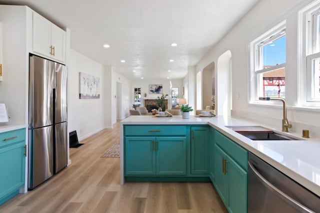 kitchen featuring sink, plenty of natural light, stainless steel appliances, and light hardwood / wood-style floors