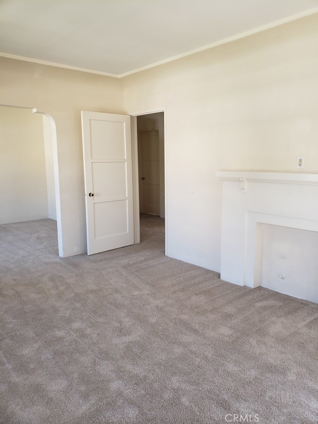 unfurnished living room featuring ornamental molding and carpet floors