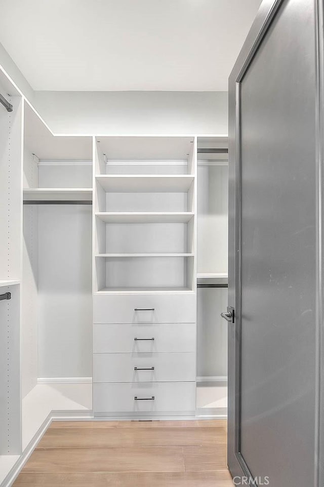 spacious closet with light hardwood / wood-style floors