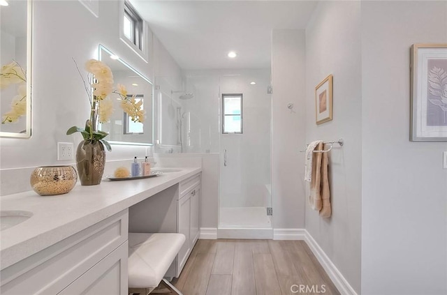 bathroom with vanity, wood-type flooring, and a shower with door